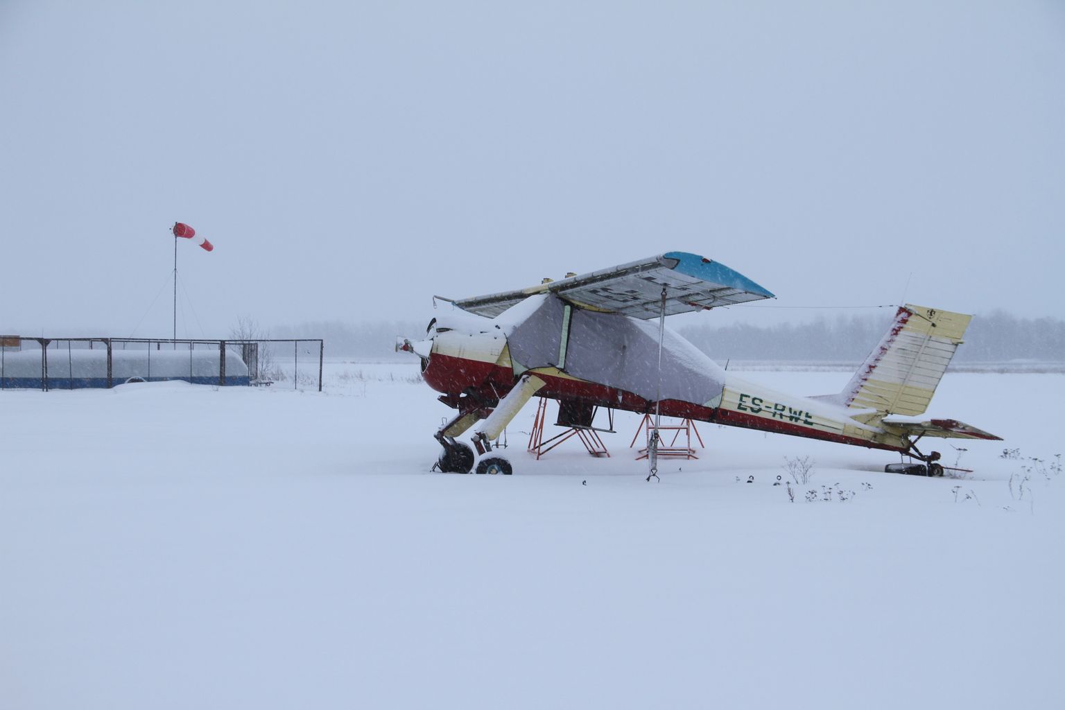 Маленький частный самолет зимует у летного поля около поселка Ольгина под Нарвой.