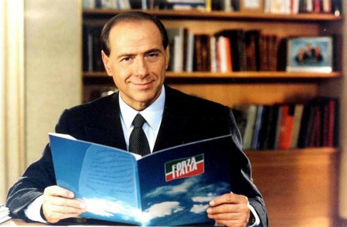Сильвио Берлускони, только что пришедший в политику в мае 1994 года, держит в руках папку с логотипом своей ультраправой политической партии Forza Italia.