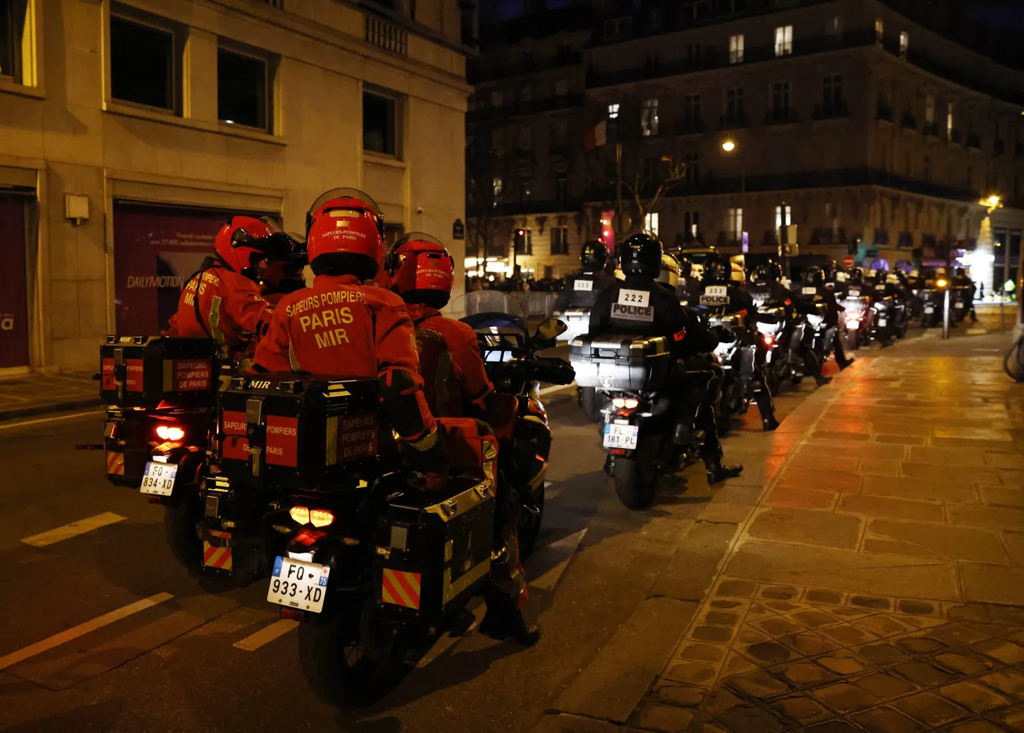 Полицейские и пожарные охраняют людей, собирающихся на Елисейских полях во время празднования Нового года в Париже, Франция.