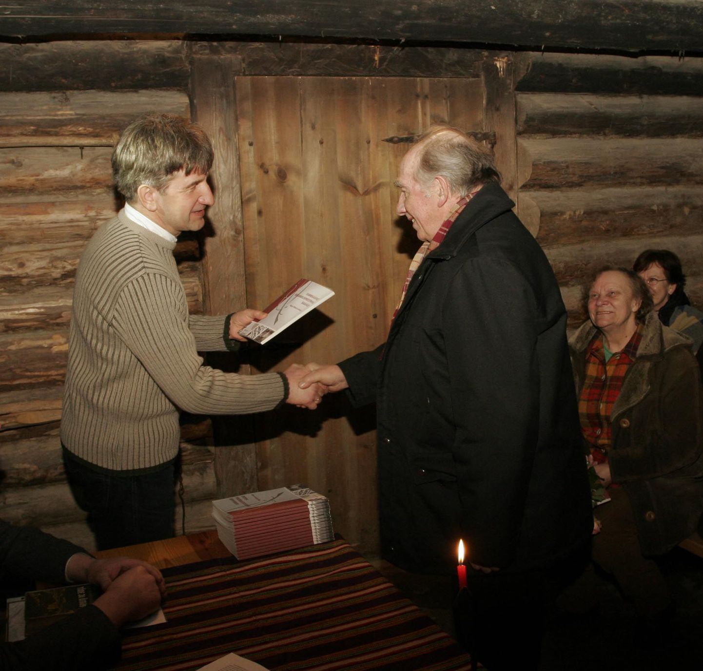 Albu vallavanem Kalju Kertsmik (vasakul) ulatab esimese raamatu kirjanduspreemia saanutest kunagise Tammsaare kolhoosi esimehele ja kirjanduspreemia asutajale Jaan Nõlvele.