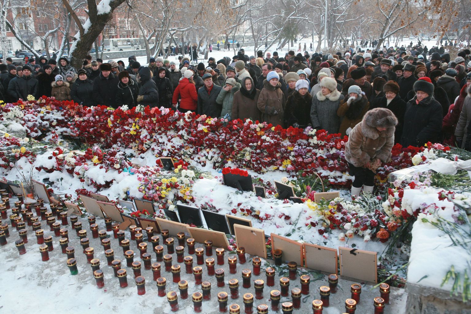Lilled, küünlad ja ohvrite fotod Lonkava Hobuse ööklubi ees Permis.
