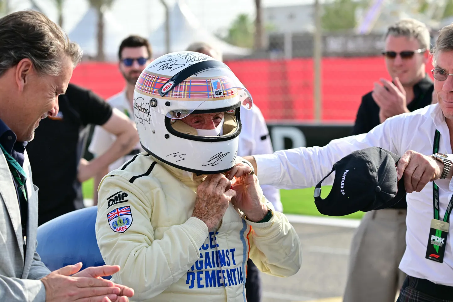 Jackie Stewart kandmas oksjonil müüki minevat kiivrit, mille kõikide elavate F1-maailmameistrite autogrammid.