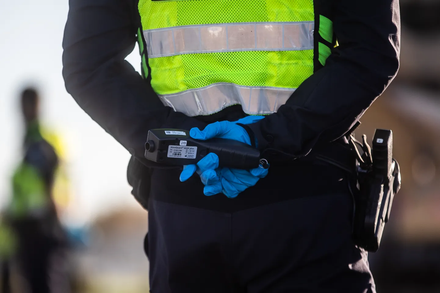 Politseinik alkomeetrit käes hoidmas