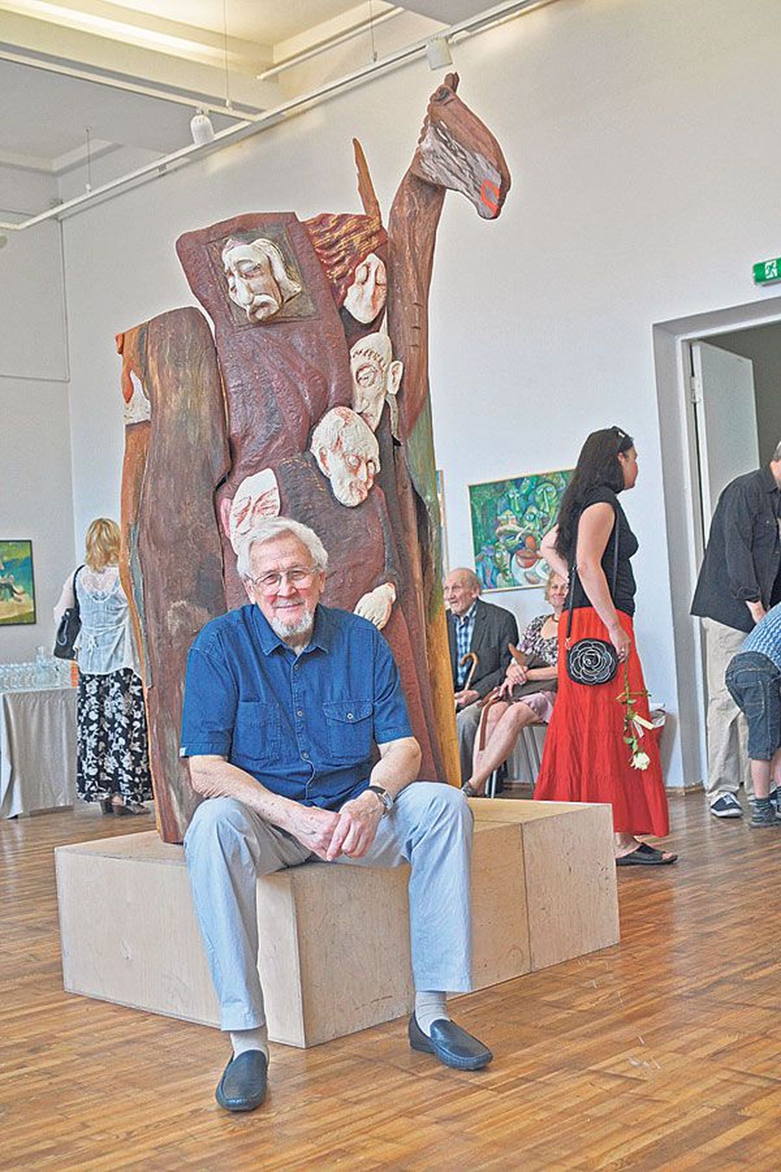 Stanislav Nechvolodov (78) puhkab oma näitusel jalga, kasutades selleks skulptuuri «Ajad» (värvitud puu, 1999–2013) alust.
