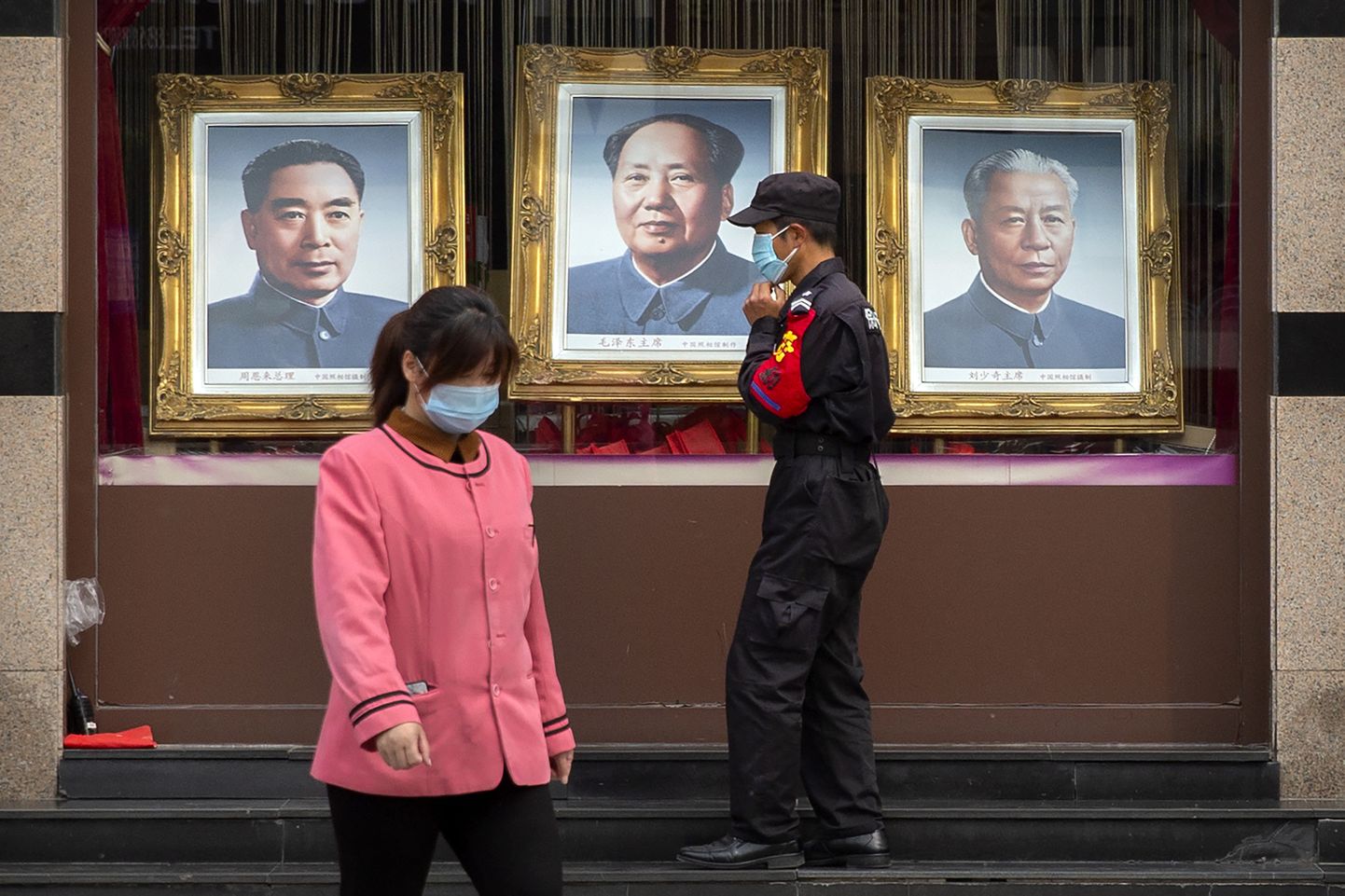 Turvamees Pekingis kommunistlike liidrite portreede juures.