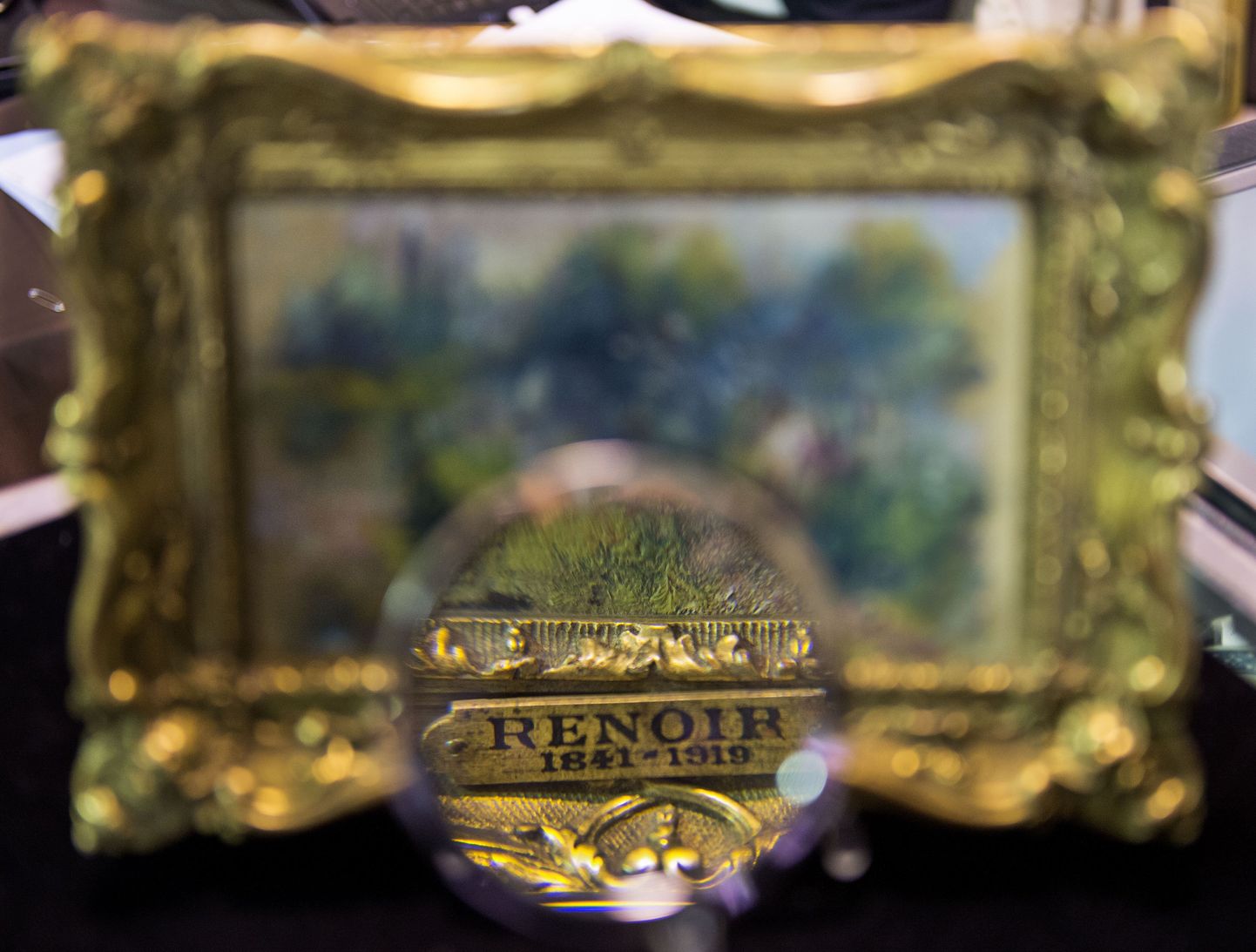An art shopper looks closely at a 5.5 inch by 6.6 inch (14 centimeter by 23 centimeter) painting by French Impressionist master Pierre-Auguste Renoir September 25, 2012 in Alexandria, Virginia. The painting was recently discovered for just a few dollars at a Virgina flea market sale. The canvas which shows a scene along the Seine River titled "Paysage Bords de Seine" is scheduled to be auctioned September 29, 2012 at the Potomack Company, in Alexandria, Virginia, selling for an expected 75,000 to 100,000 USD. It was for sale in a box with a plastic cow and a Paul Bunyan doll  for 50.00 USD and still carries a label from the Berheim-Jeune arthouse in Paris, a famous purveyor of works by Renoir.   AFP PHOTO/Paul J. Richards