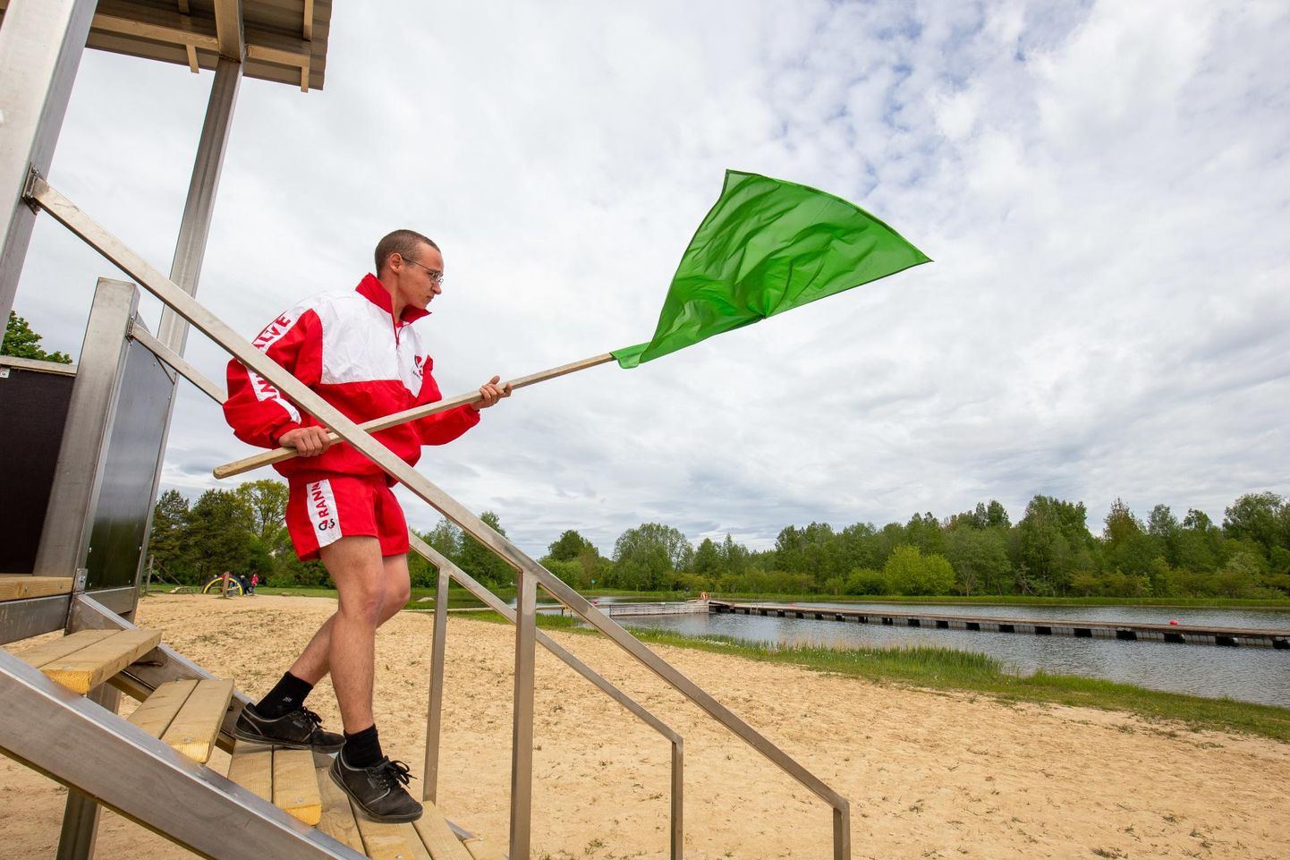 Rannavalvur Taavo-Tamur Tubli üks esimesi tööülesandeid on sättida paika roheline lipp, mis lubab inimestel vette suplema minna.