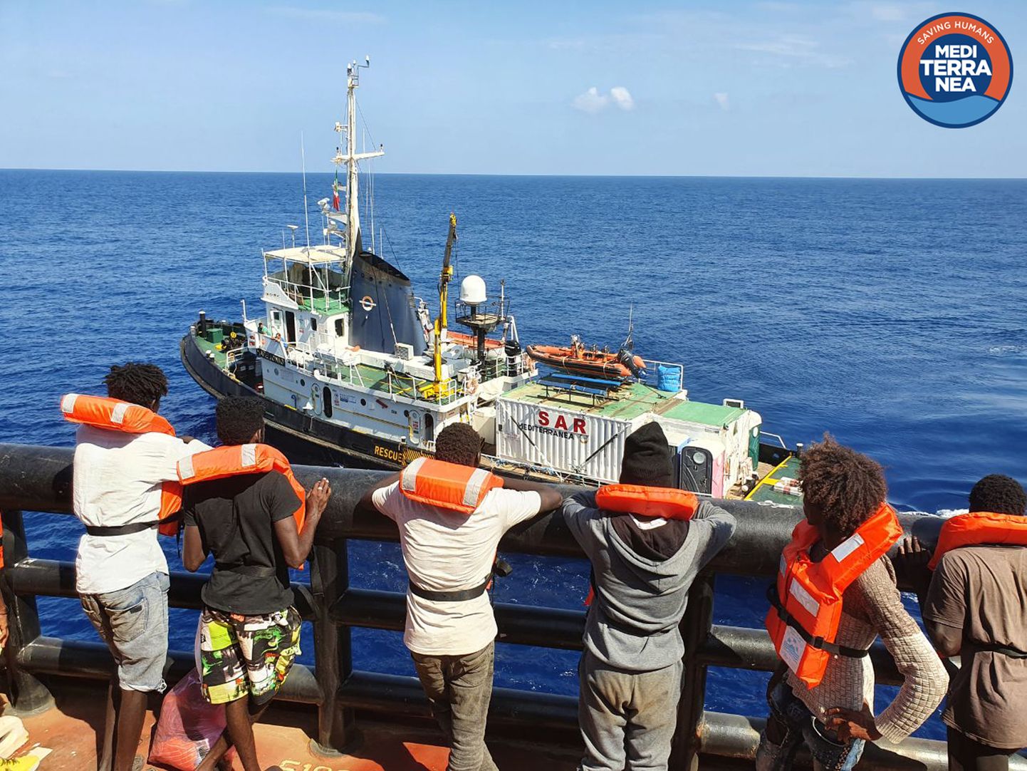 Migrandid ootamas pääsu päästelaevale Mare Jonio (taustal)