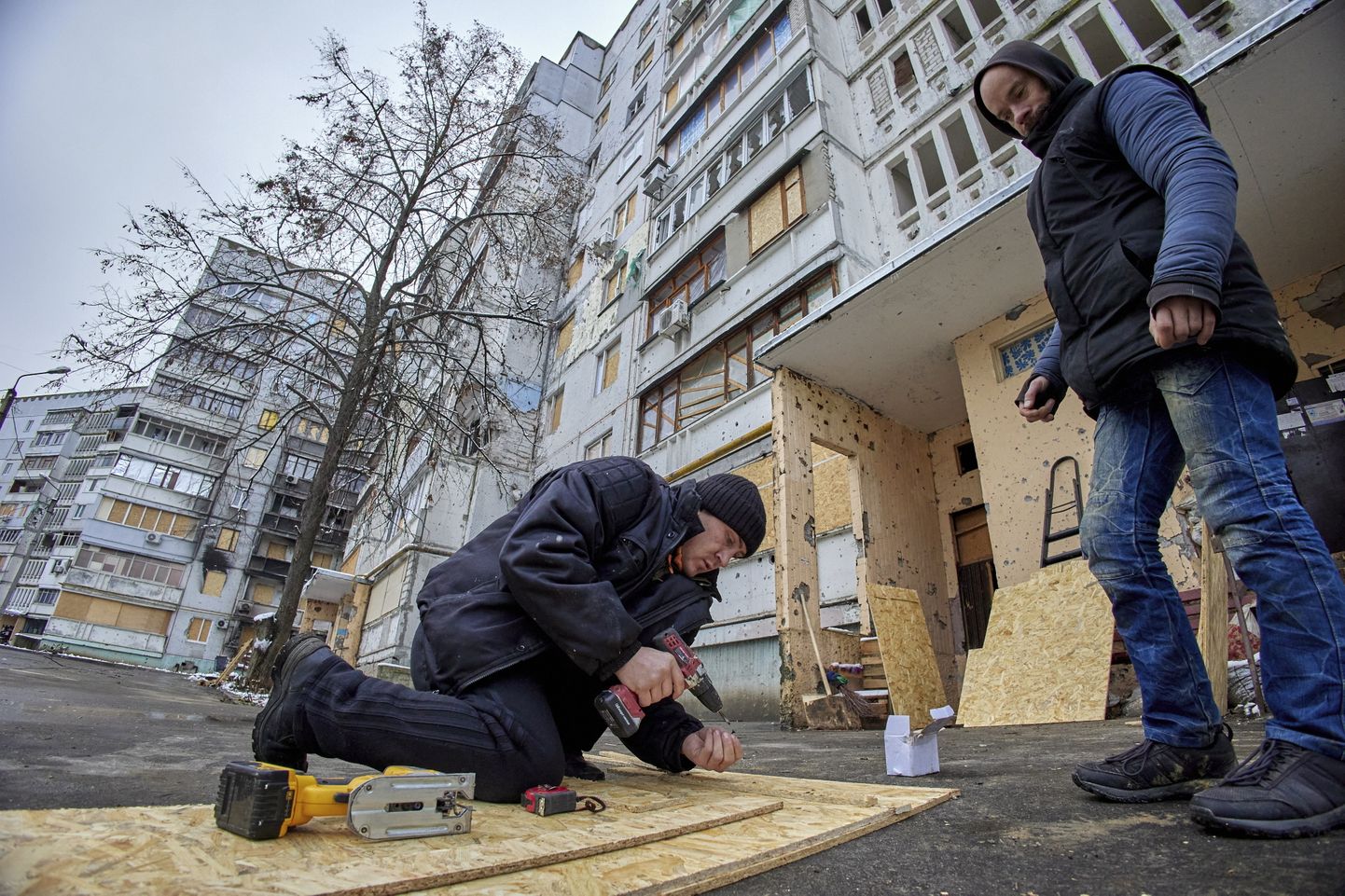 Töölised parandavad elumaja Ukrainas Harkivis 24. november 2022.