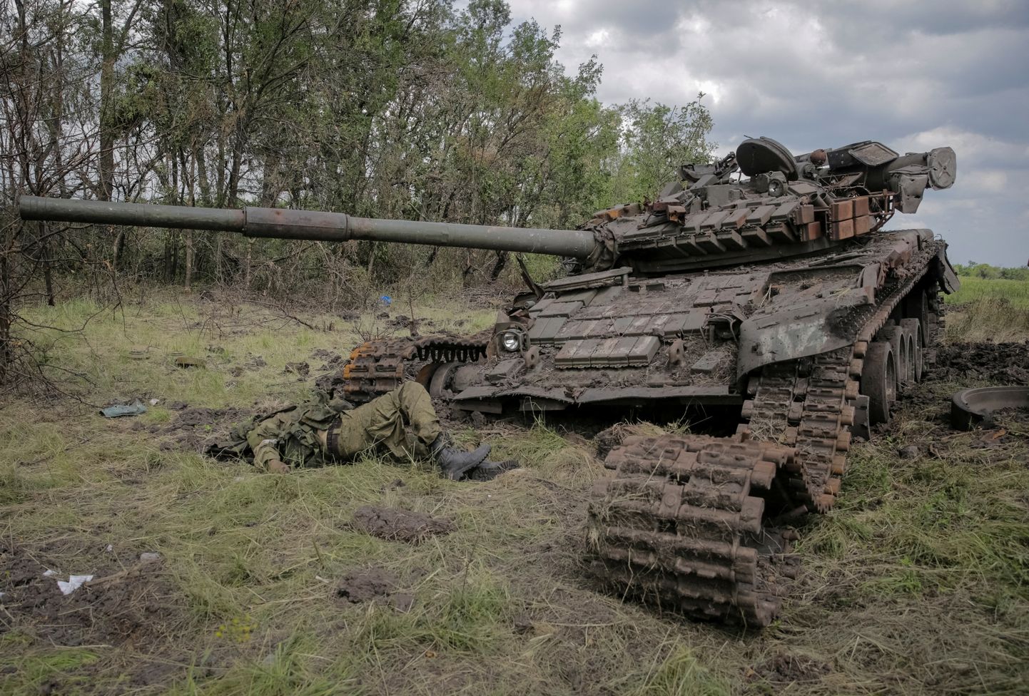 Погибший российский военный рядом с с уничтоженным танком.