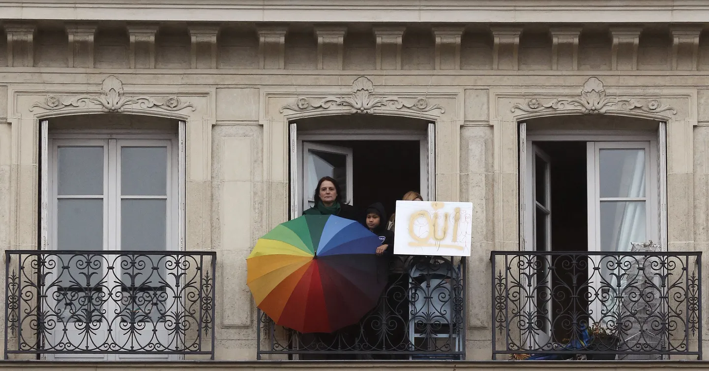 Samasooliste abielu toetavad inimesed ühel Pariisi rõdul vikarkaarevärvides vihmavarju ja plakatiga, millele on kirjutatud suurelt «JAH».