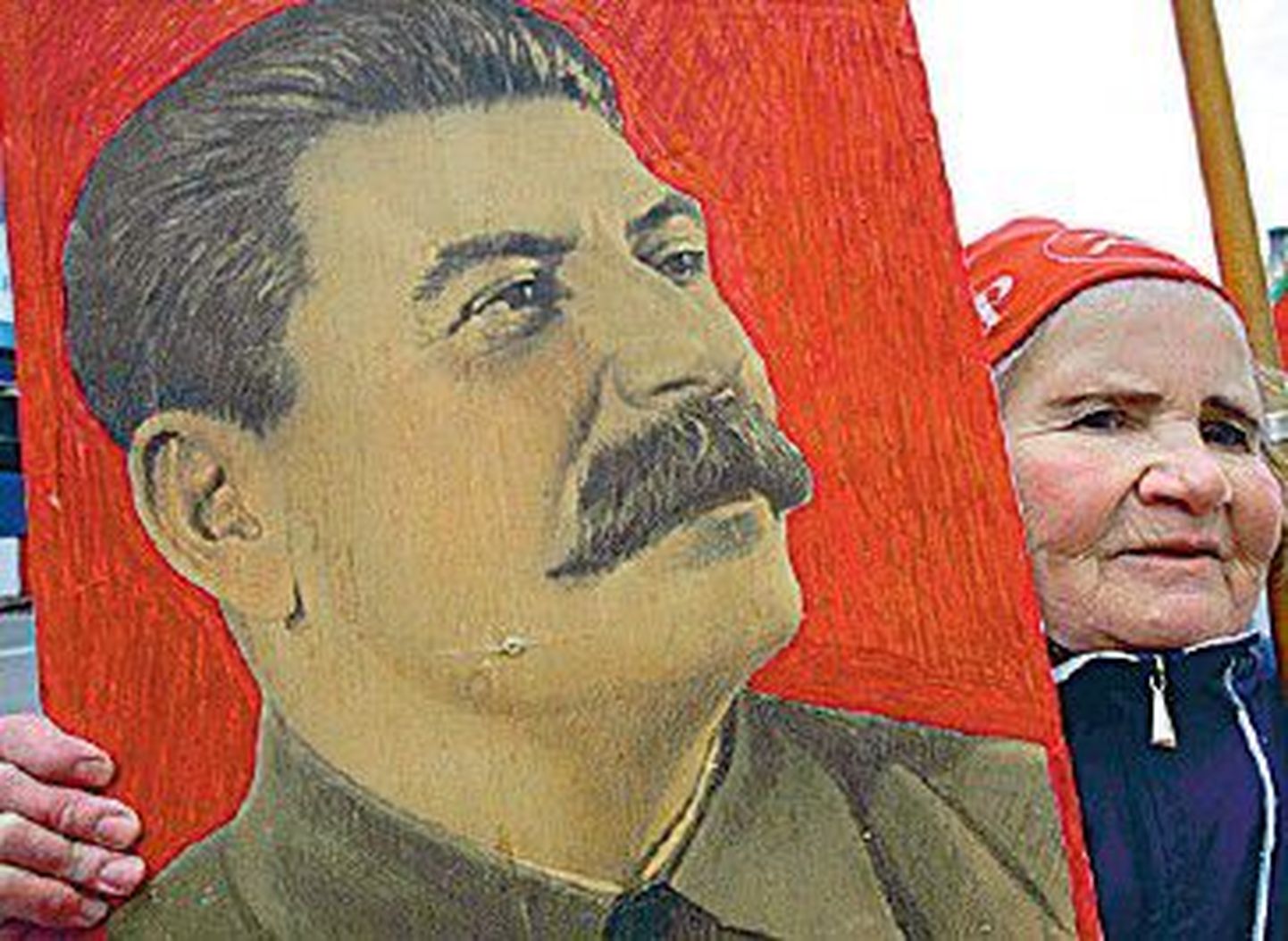 Пожилая женщина с портретом Иосифа Сталина - фактического главы советского государства в 1922-1953 годах. Только в годы «Большого террора» 1937-1938 годов под руководством и с согласия Сталина были арестованы полтора миллиона человек, из них около 700 тысяч приговорены к расстрелу.