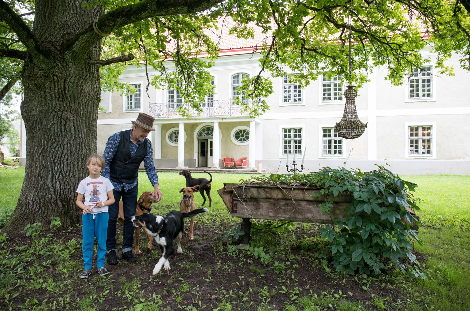 Ohtu mõisnik Erik Laansoo lapselapse Karl-Eriku ja pere koertega oma koduõuel.