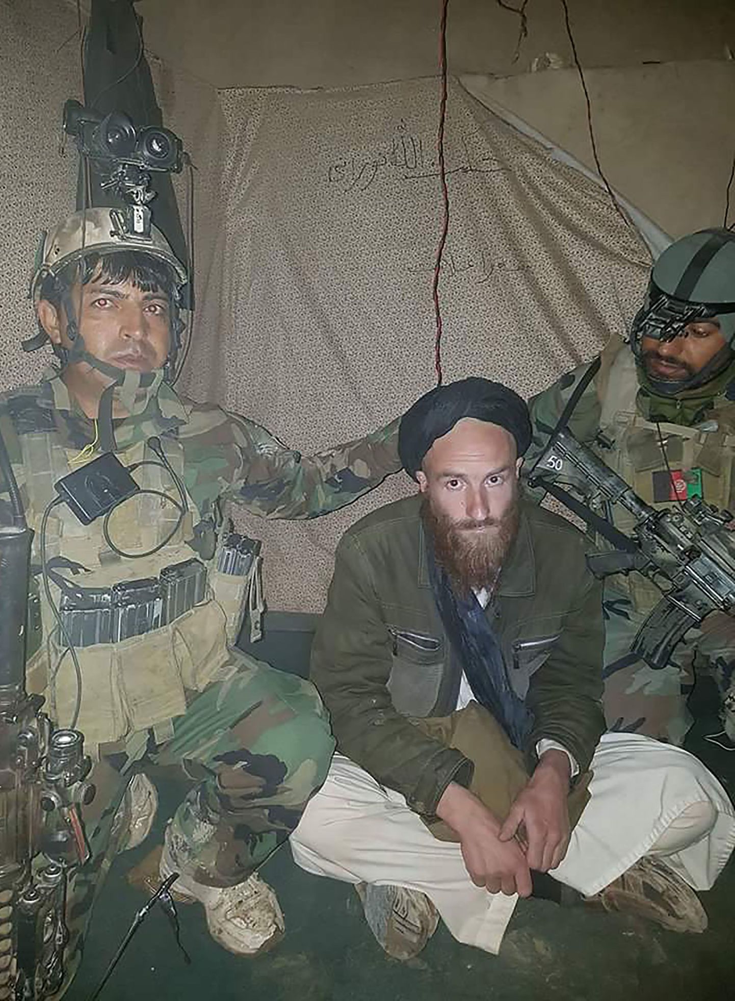 Afganistani sõjaväe avalikustatud fotol on näha Talibani nõustanud meest (keskel), kes vahistati Helmandi provintsis ja on enda väitel Saksamaa kodanik.