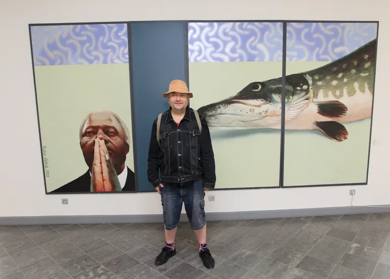 Tartu kunstimuuseumis juunis 2017 tehtud fotol seisab Peeter Allik oma isikunäitusele «Kultiveeritud skisofreenia» välja pandud maali «ÜRO» juures.