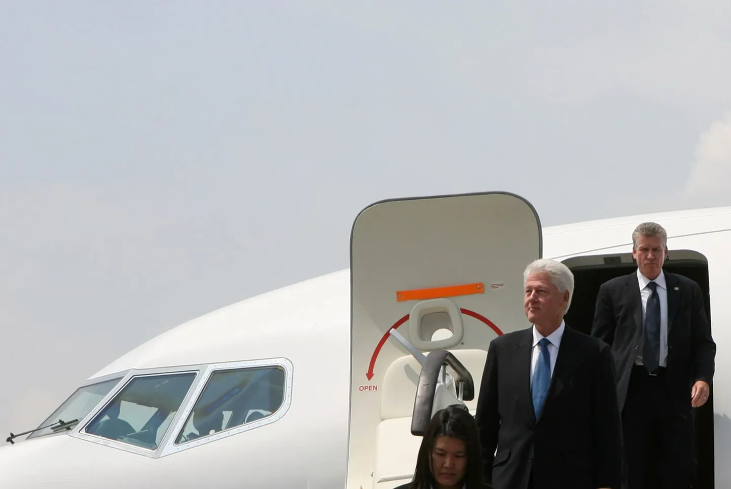Ühendriikide endine president Bill Clinton (keskel) väljub lennukist Pyongyangis.
