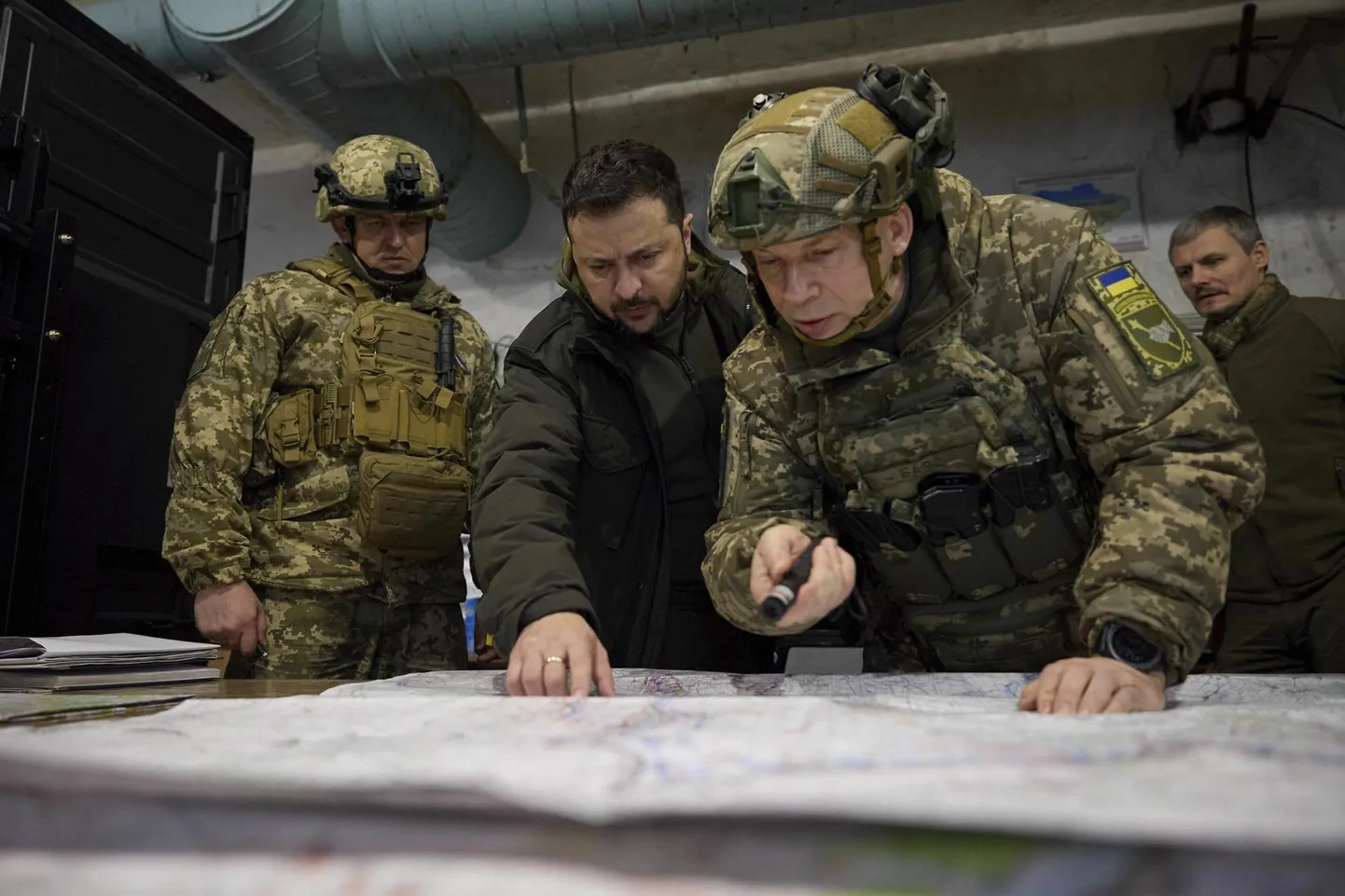 Ukraina president Volodõmõr Zelenskõi (keskel) uurimas sõjakaarti koos oma uue esikaitseväelase Oleksandr Sõrskõiga.