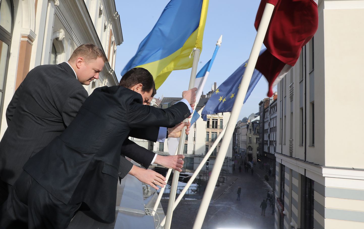 Rīgas domes vicemērs Edvards Smiltēns (no kreisās) un Ukrainas vēstnieks Latvijā Oleksandrs Misčenko pie Rīgas rātsnama paceļ Ukrainas karogu, paužot atbalstu Ukrainas suverenitātei un integrācijai Eiropā.