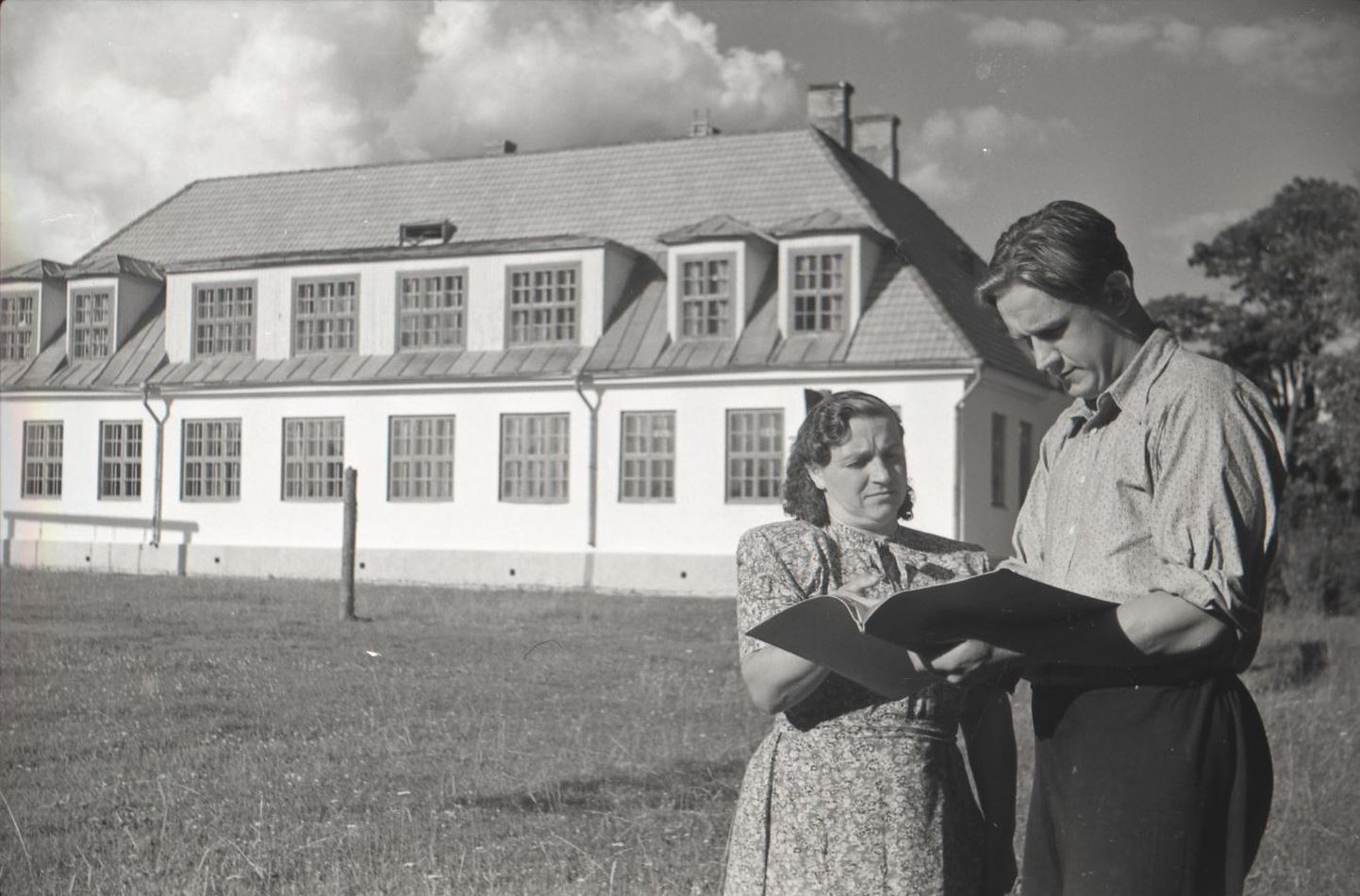 Kooliteenija Juuli Saviir ja direktori asetäitja Adolf Valler Haimre remonditud koolihoone ees, 1949.