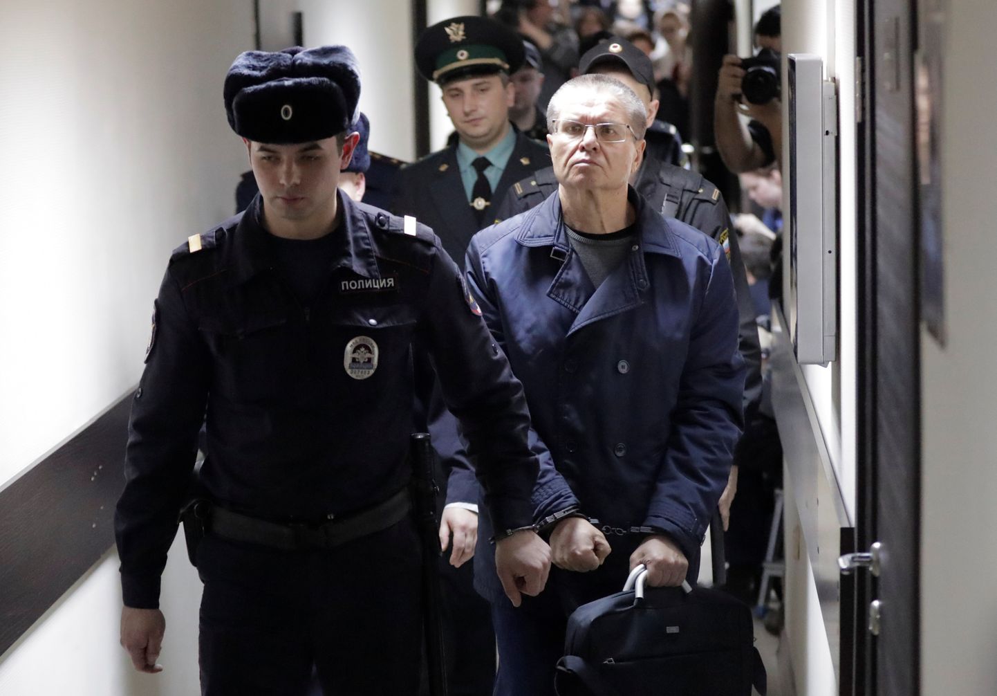 Politseiametnikud eskortimas endist Vene majandusarenguministrit Aleksei Uljukaevit pärast otsust kohtusaalist välja.