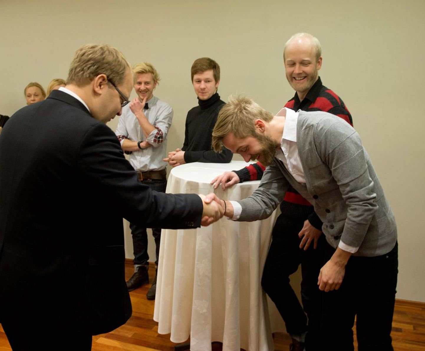 Fotol surub Urmas Paet kätt Erki Pärnojal. taamal rõõmustavad Ewert Sundja, Kristjan Kallas ja Ivo Etti.