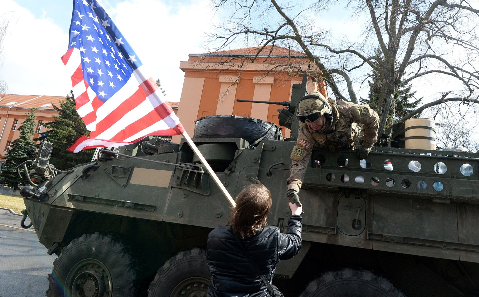 USA sõdur surub kätt Tšehhi elanikult, kes hoiab USA lippu, 30. märtsil 2015. USA sõjaväekolonn, mis alustas liikumist Baltimaadest ja lõpetas Saksamaal, sai teel paljude kohalike tervituse osaliseks. Pilt on illustratiivne.