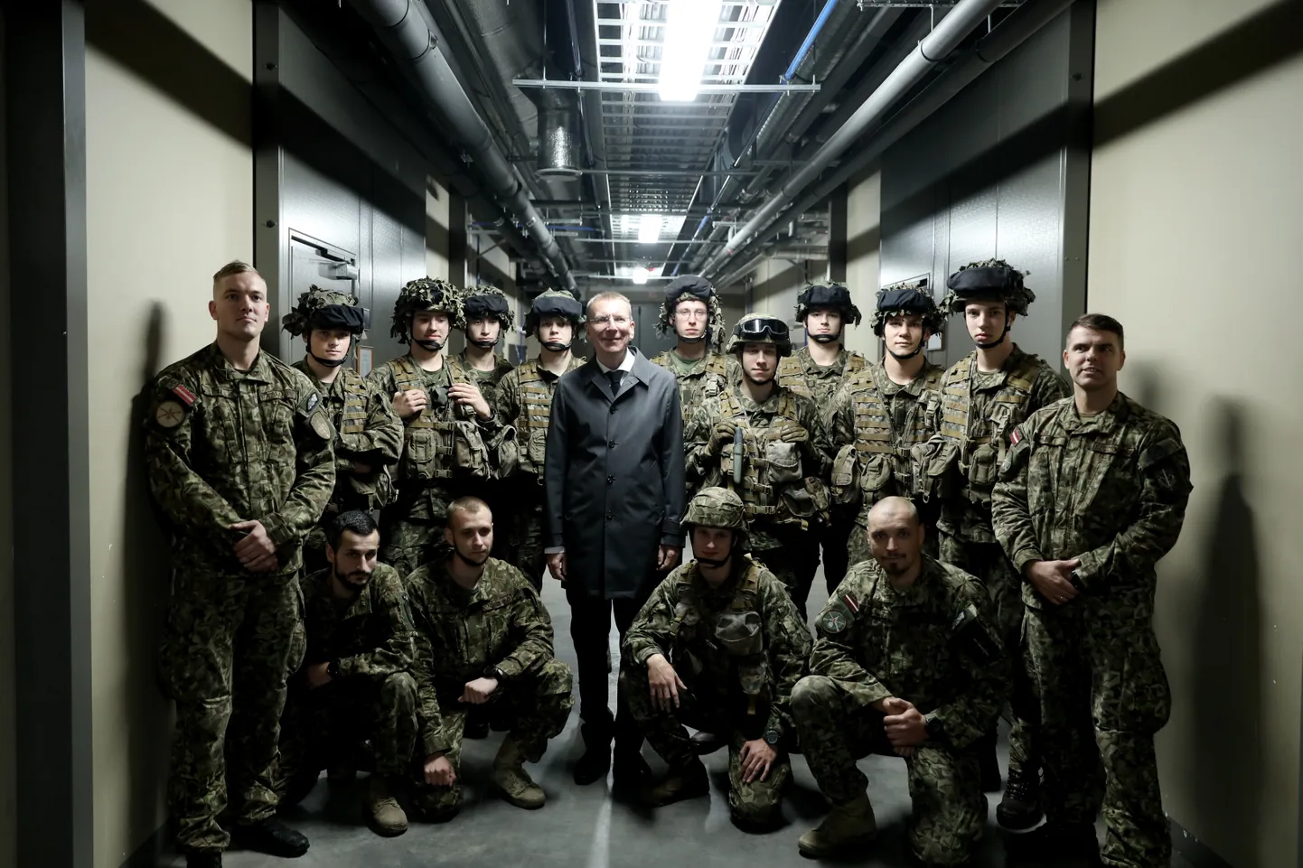 Valsts prezidents Edgars Rinkēvičs (centrā) Ādažu militārās bāzes apmeklējuma laikā.