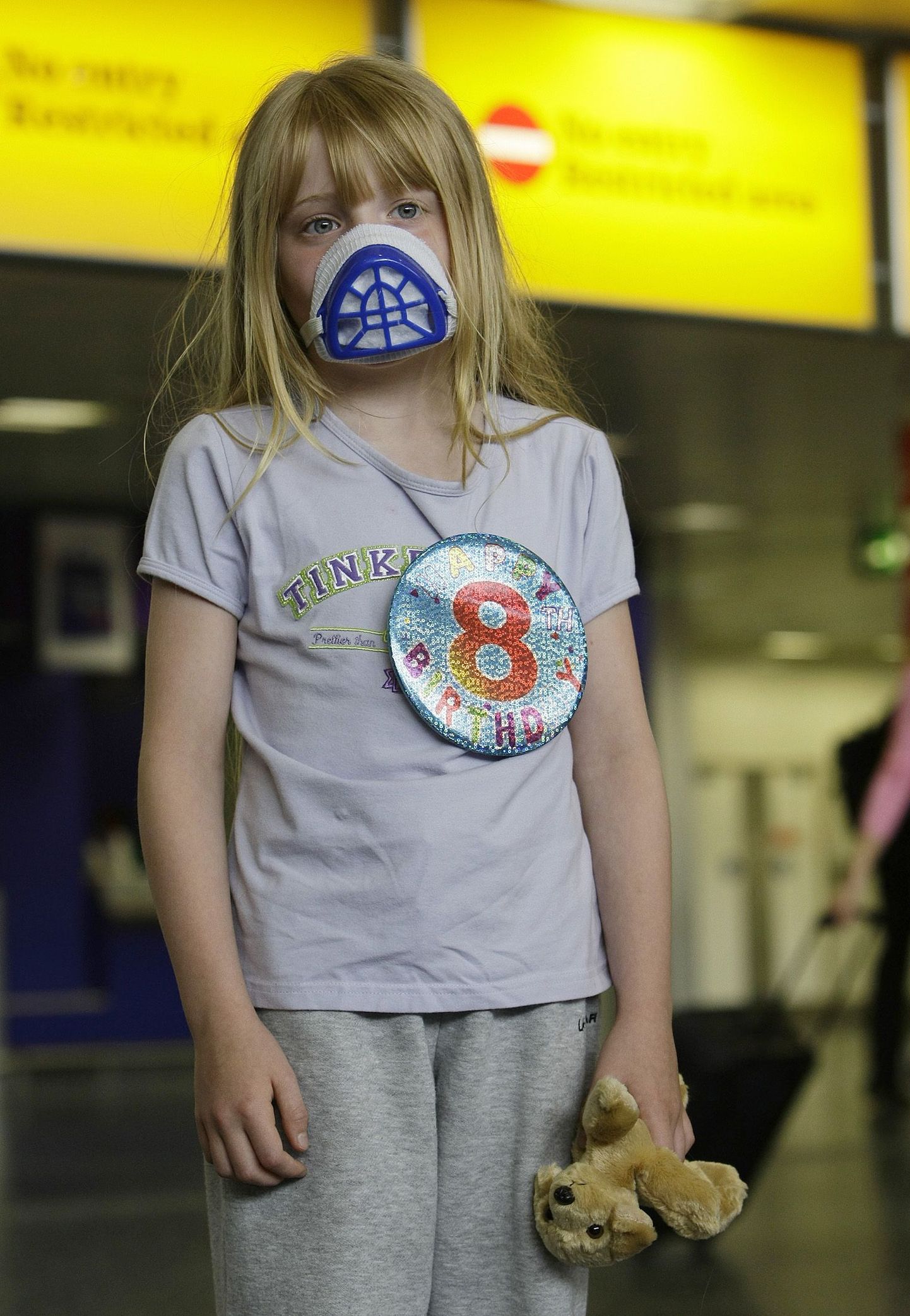 Ребенок в респираторной маске в лондонском аэропорту Гэтвик.