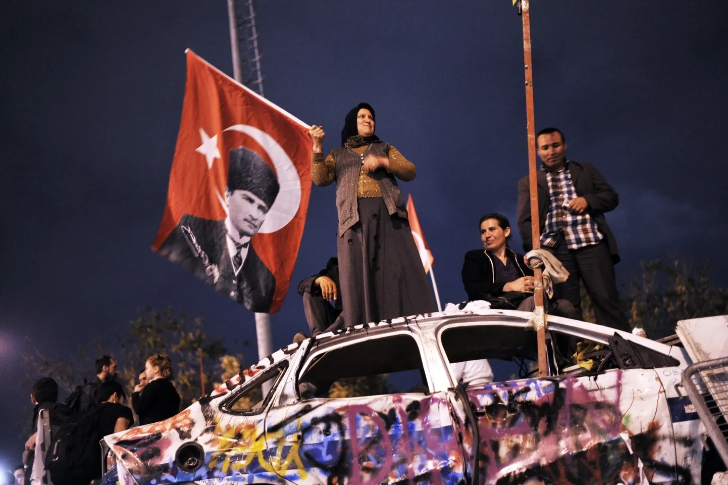Valitsusvastased meeleavaldajad lehvitavad Türgi lippu, millele on riigi rajanud Mustafa Kemal Atatürki foto.