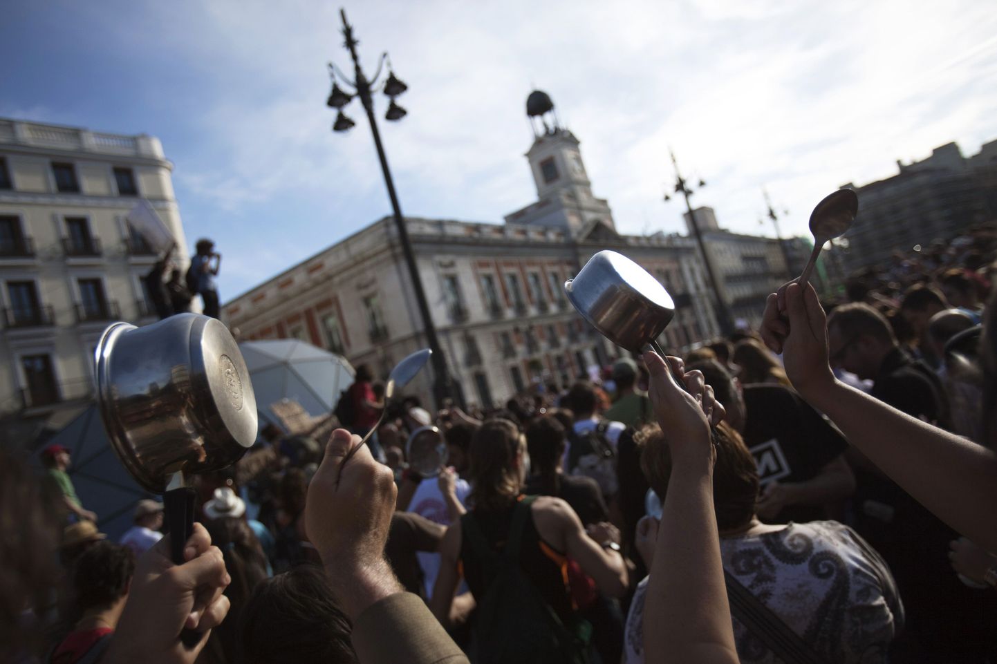 People banging on saucepans with spoons shout slogans during a gathering marking the one year anniversary of Spain's Indignados (Indignant) movement in Madrid's Puerta del Sol May 15, 2012. Dubbed "los indignados" (the indignant), the movement which spawned similar protests worldwide, has called for 96 hours of continuous protest to culminate at the Puerta del Sol square where the movement was founded a year ago in a renewed protest over government austerity measures, banks, politicians, economic recession, and the highest unemployment in the eurozone. REUTERS/Juan Medina(SPAIN - Tags: CIVIL UNREST POLITICS SOCIETY)