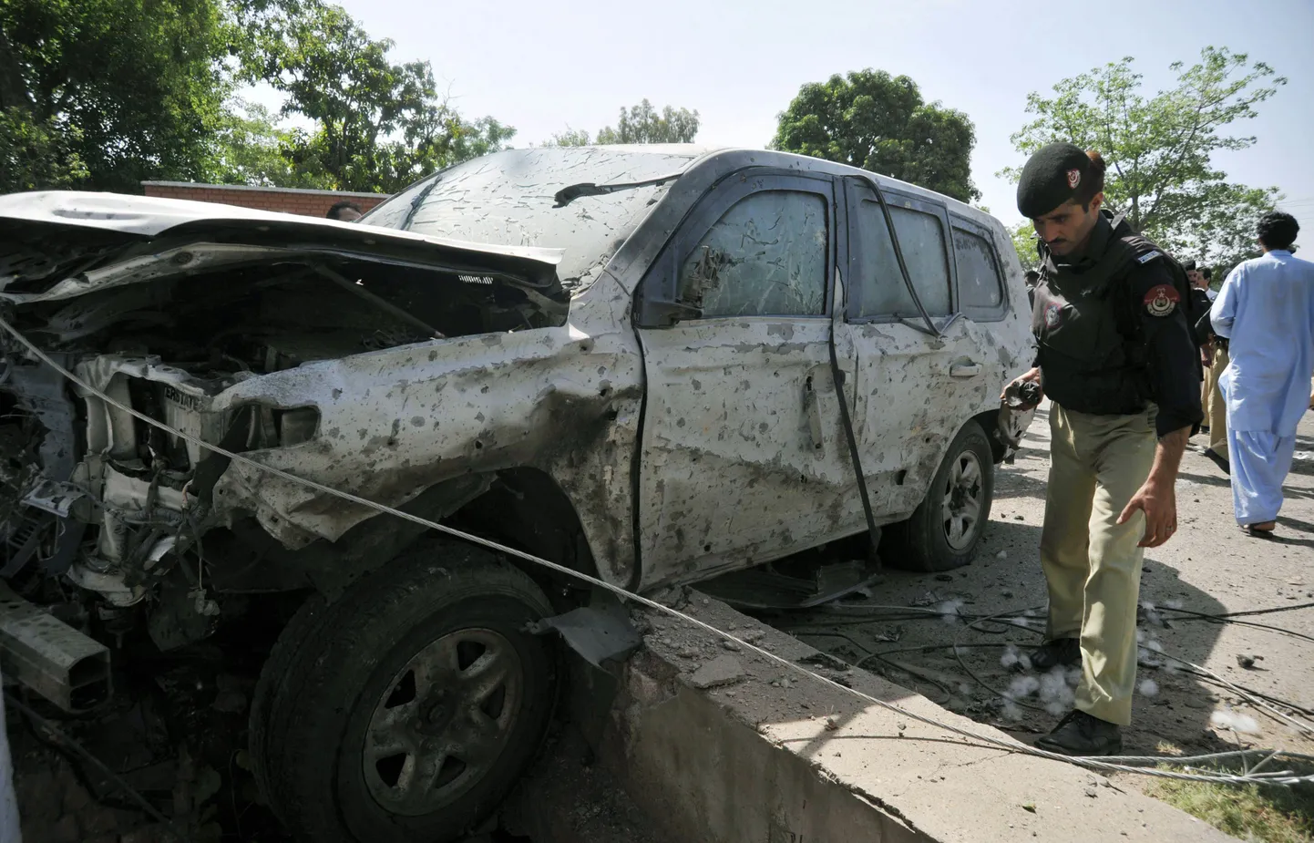 Pakistani politseinik Peshawaris pommirünnakus hävinenud USA konsulaadi auto juures.