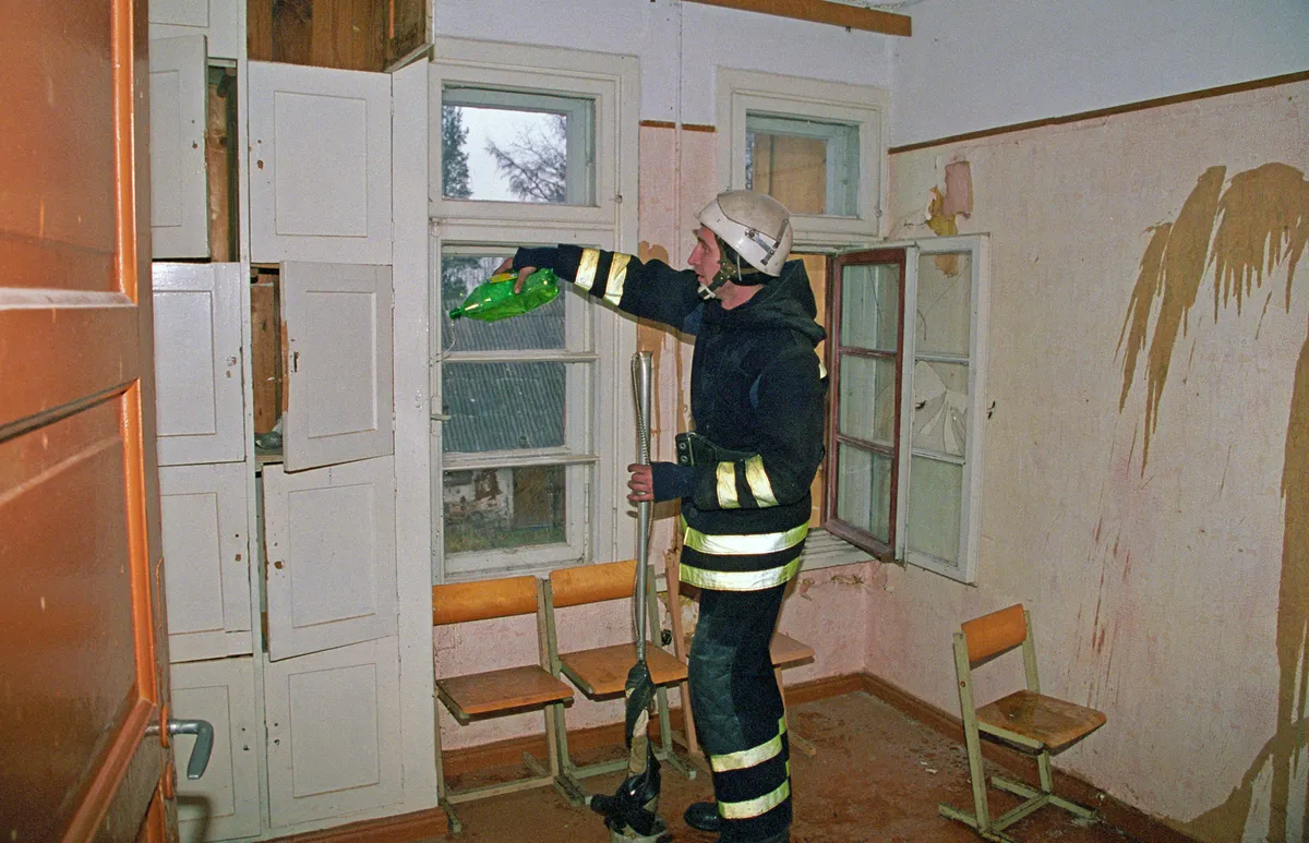 Tuletõrjuja valmistab ette Nõo koolimaja süütamist. 3.november 1998.