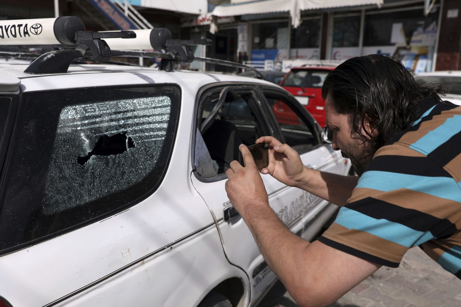 Ajakirjanik tegemas pilte autost, milles tapeti Afganistani valituse meediakeskuse direktor Dawa Khan Menapal