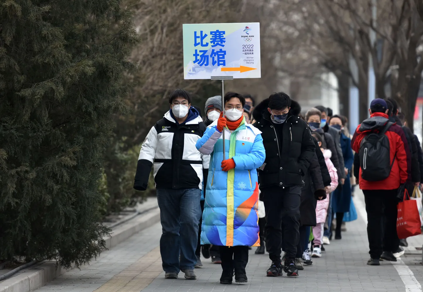 Vabatahtlik (plakatiga) 11. veebruaril Pekingis pealtvaatajaid positsioonidele paigutamas.