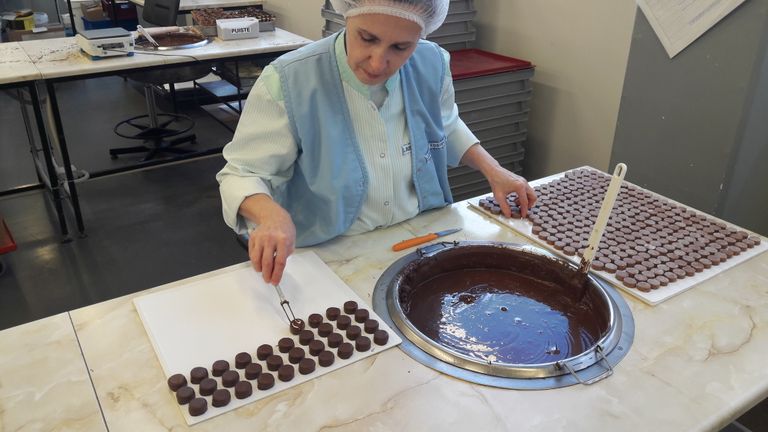 Nii valmivad Kalevis käsitööna valmistatavad šokolaadikommid. Pildil olev kommimeister Ljudmilla Kostenko on tootearendusjuht Evelin Heibergi sõnul üks staažikamaid ning hinnatumaid töötajaid. 