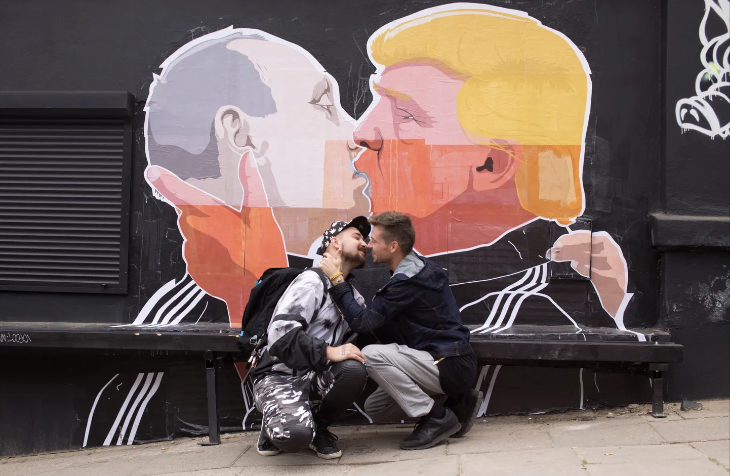 Seinamaaling Venemaa president Putinist ja USA presidendikandidaat Trumpist suudlemas ja geipaarist selle ees