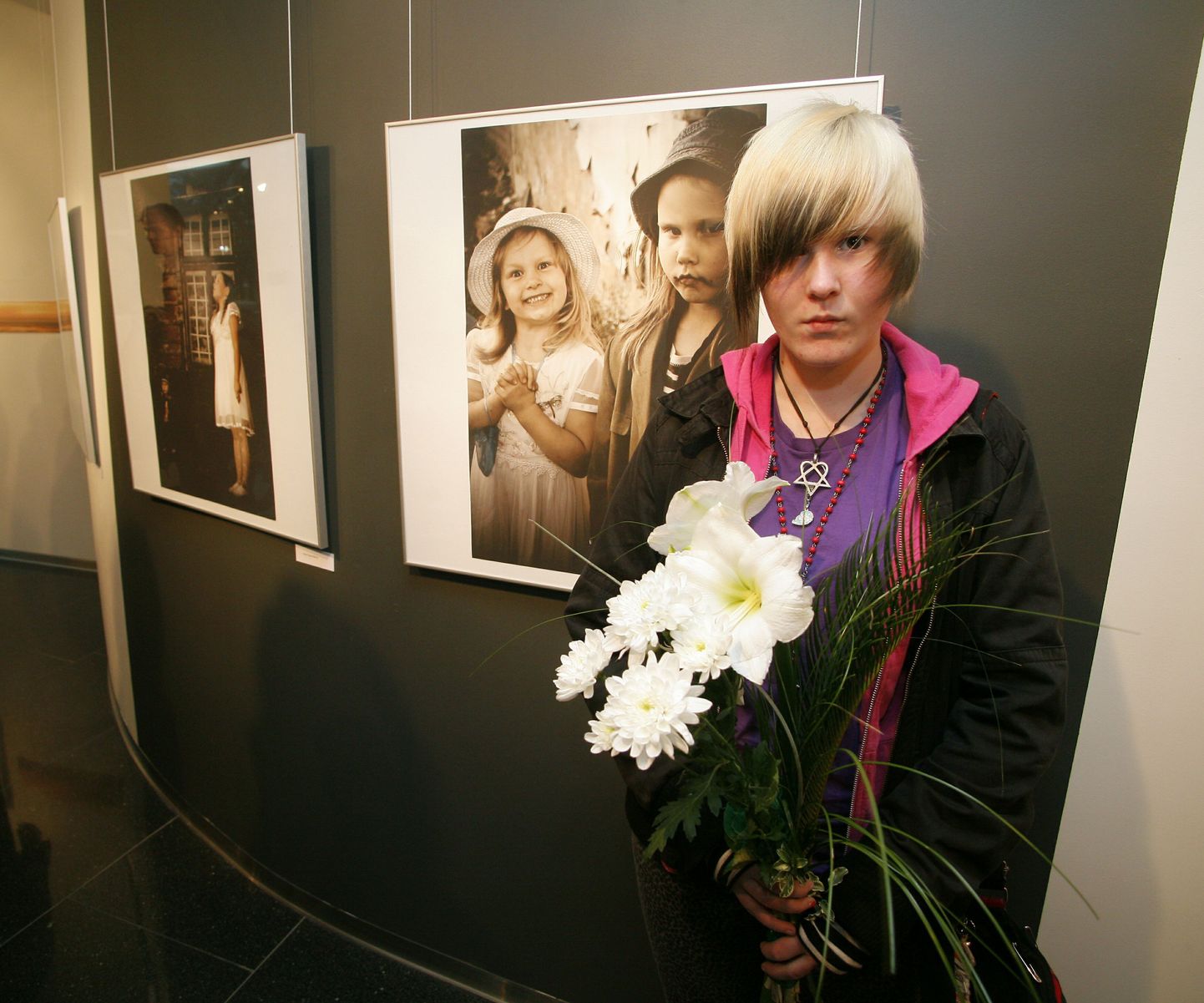 Grete Raspen Masing oma fotode taustal.