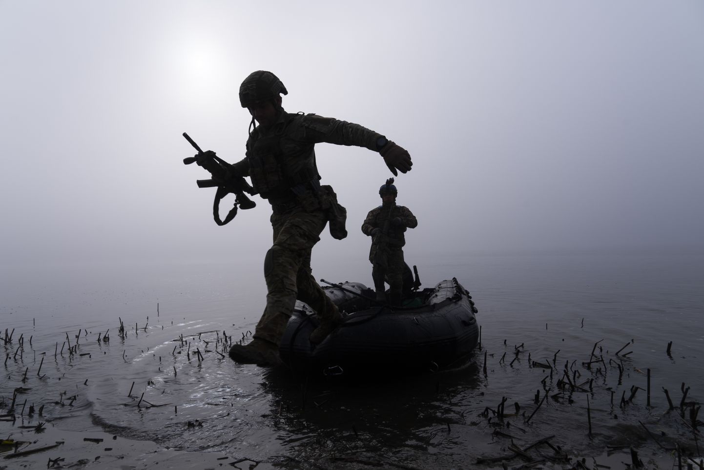 Украинский военнослужащий выпрыгивает из лодки на берегу Днепра на передовой под Херсоном, Украина. 15 октября 2023 г.