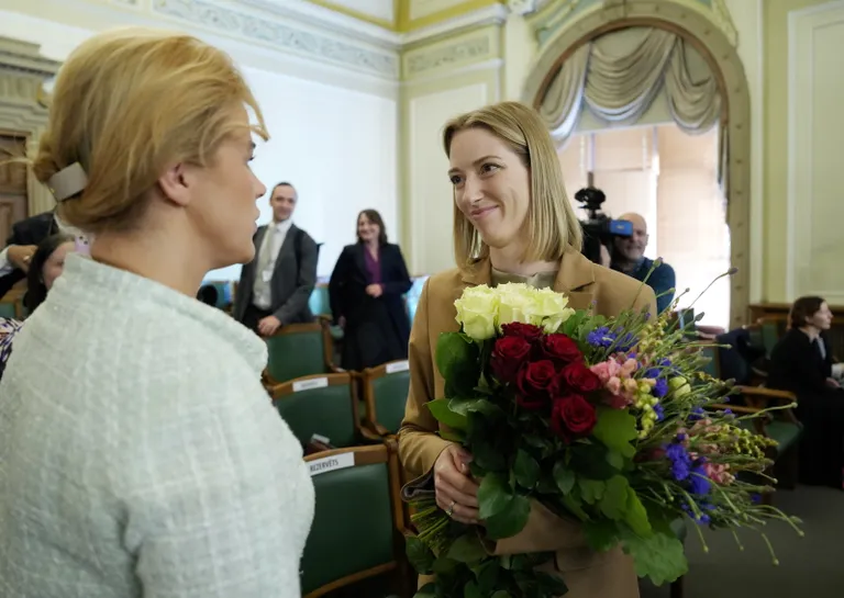 Prime Minister Evika Siliņa (left) greeting the newly elected Minister of Culture Agnese Lāce during the closing sitting of the spring session of the Saeima.