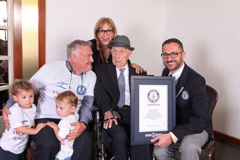 Guinnessi rekordite raamatu esindaja Marco Frigatti, maailma vanima mehe tiitlit kandnud Yisrael Kristal ja tema pereliikmed 2016. aastal.