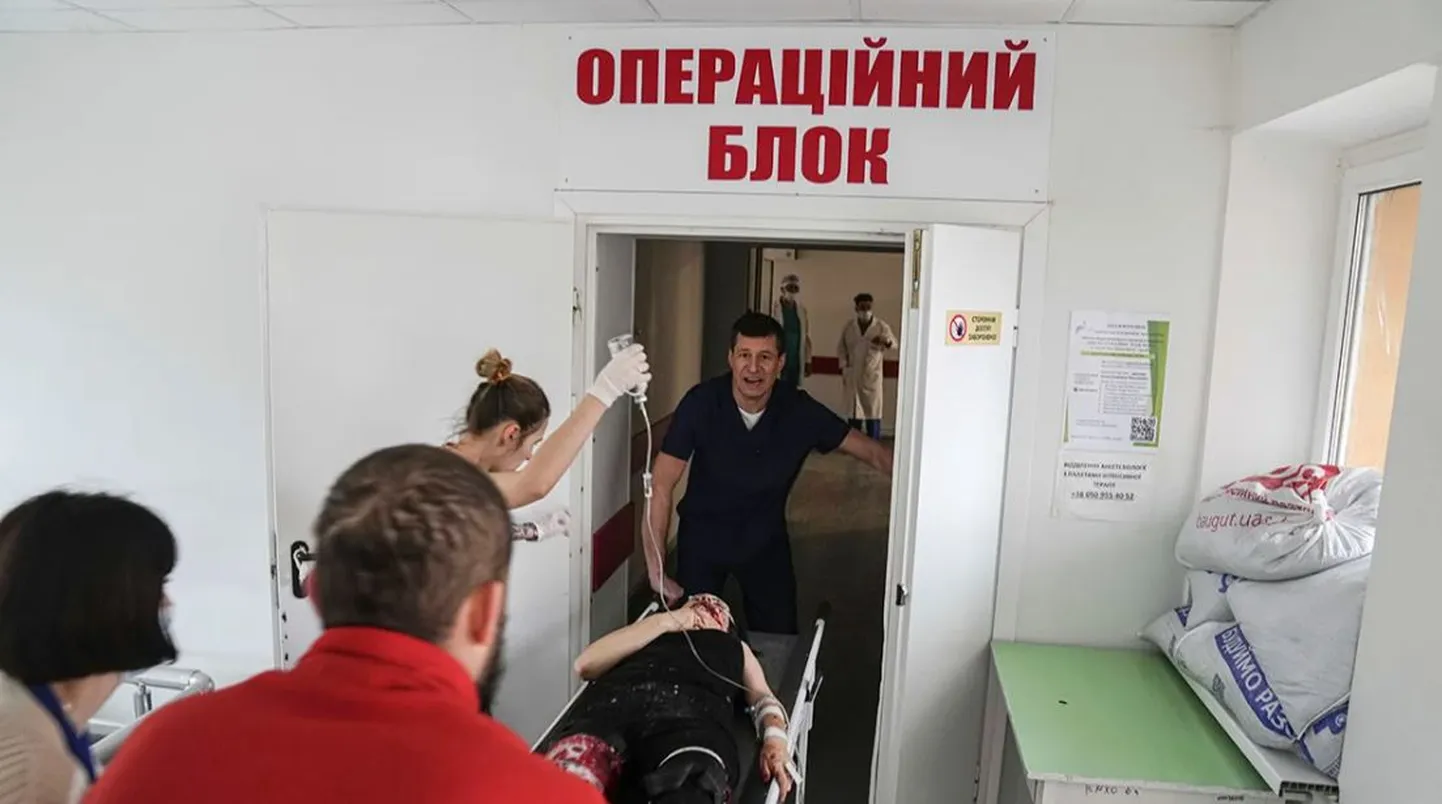 Фельдшер скорой помощи ввозит в операционную носилки с женщиной, пострадавшей в результате обстрела жилого района, Мариуполь, Украина, 1 марта 2022 года.