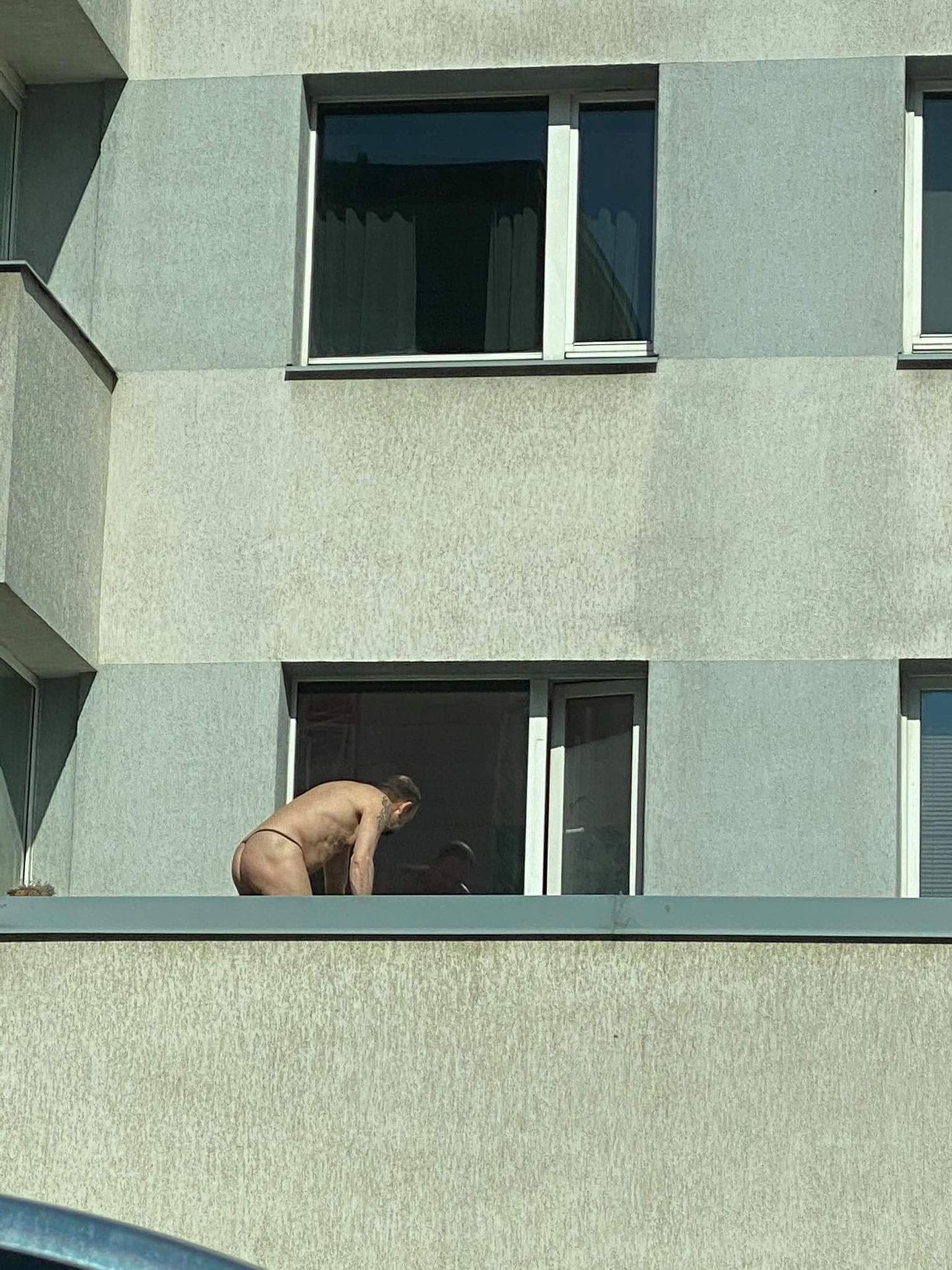 Мужчина практически голышом моет окна
