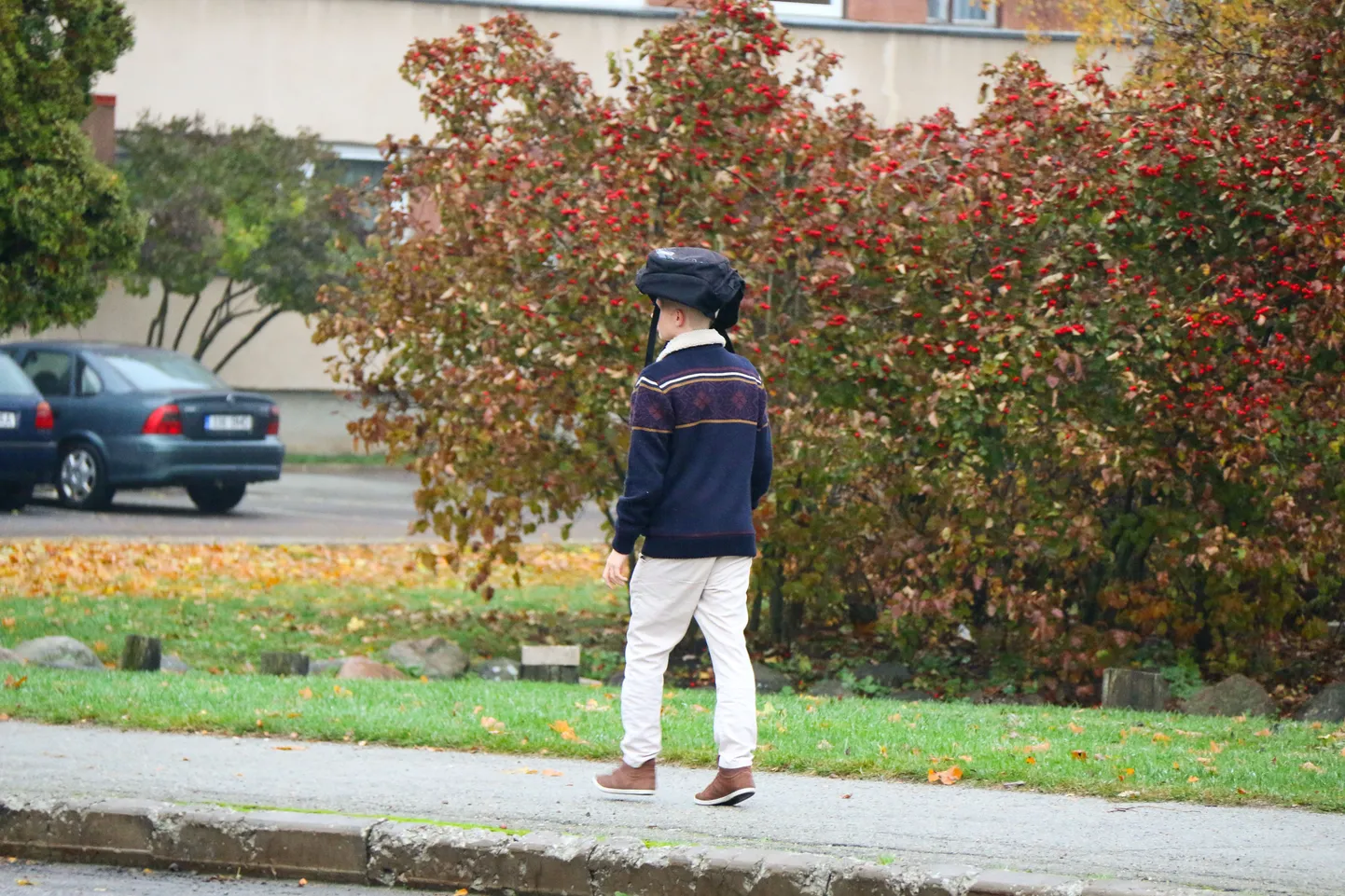 Noormees seljakotti vihmavarjuna kasutamas.