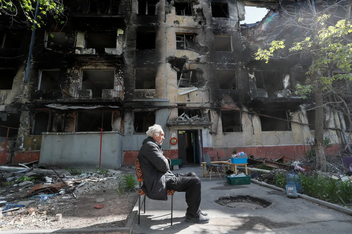 Kohalik elanik pommitatud Mariupolis pingil istumas.