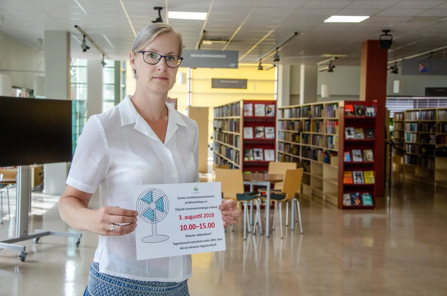 Raamatukogu direktor Reet Lubi näitas eile teise korruse teenindussaalis silti, mis klientidele eelmisel nädalal ajutisest sulgemisest teada andis.