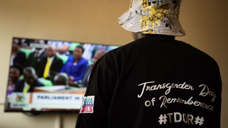 Трансгендерная женщина из Уганды, которая недавно подверглась нападению, смотрит голосование по телевизору