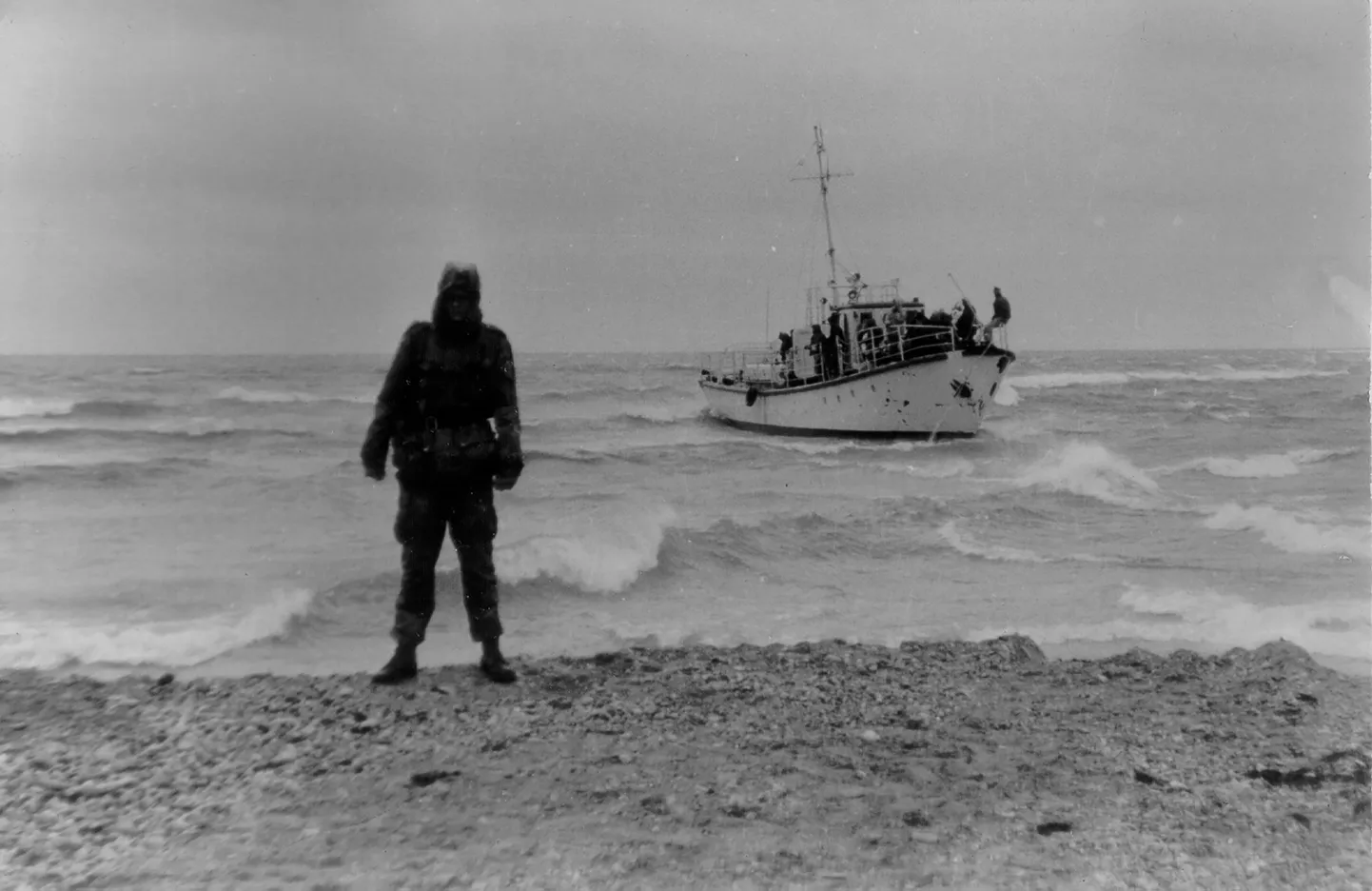 Piirivalvur seisab Sõrve rannas, tema seljataga madalikule jooksnud "Katran".