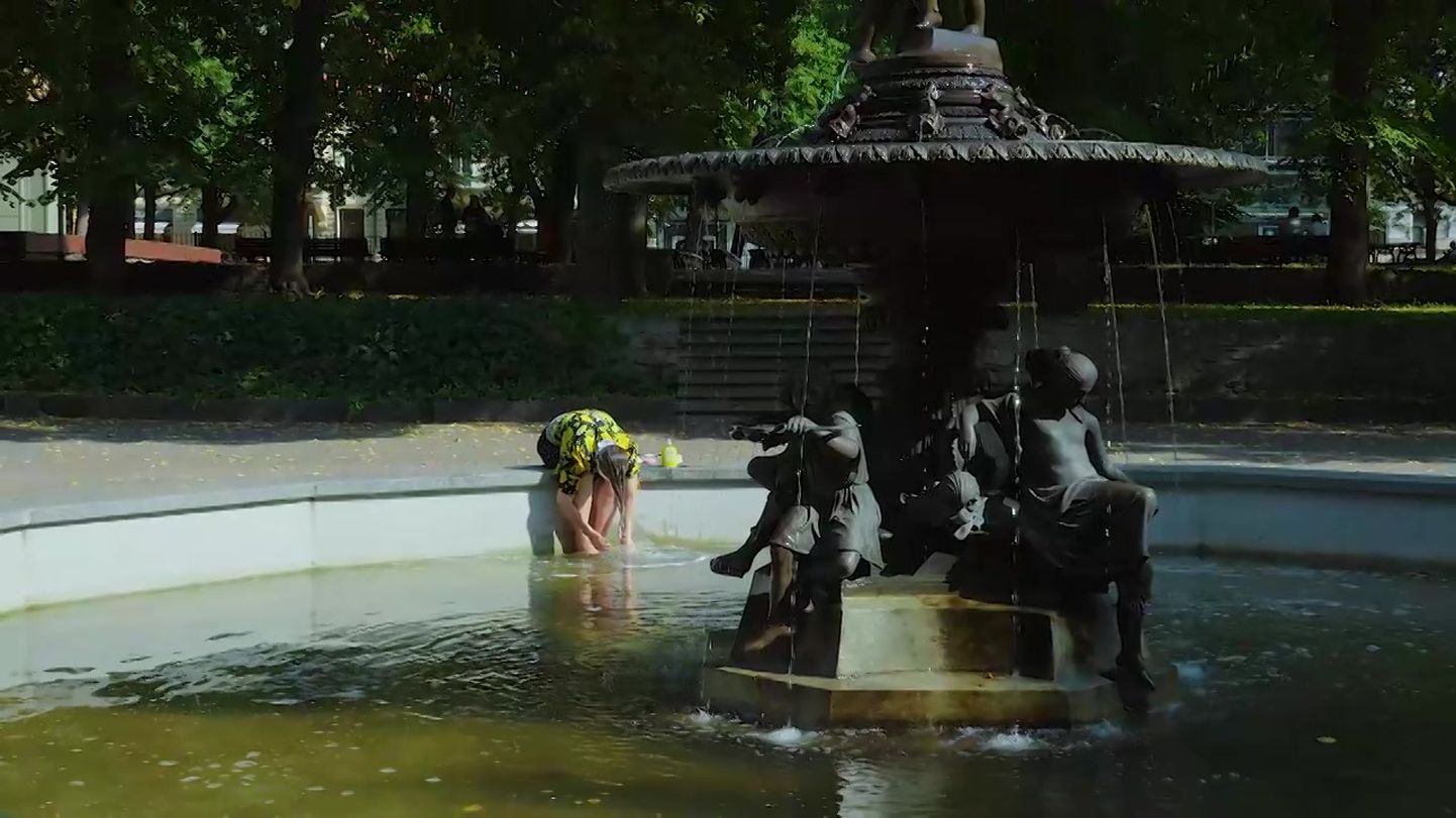 Женщина моет волосы в историческом фонтане Верманского сада