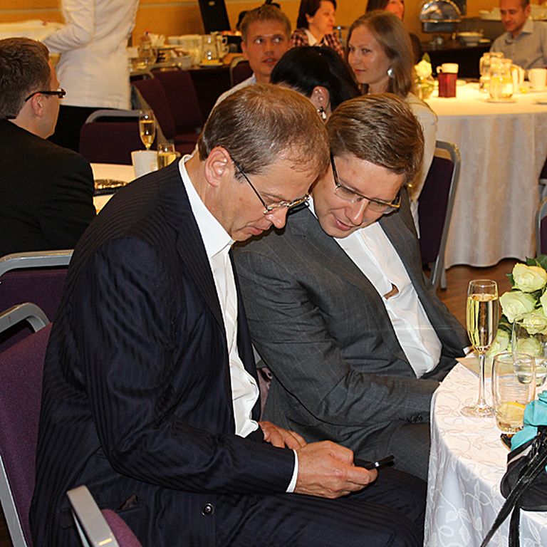 Gluži kā brāļi - Andris Ameriks (no kreisās) un Nils Ušakovs lasa pirmos apsveikumus, kas atnākuši uz mobilo tālruni 
