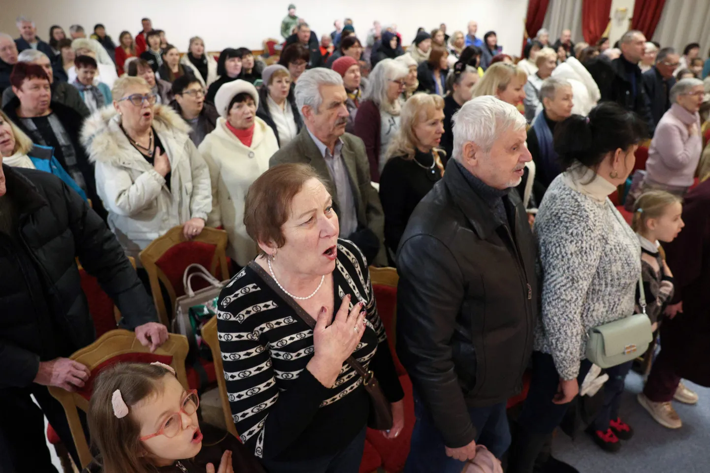 Внутренние переселенцы из оккупированного Бахмута исполняют гимн Украины на рождественском концерте, организованном вчера в Киеве изгнанным городским собранием.